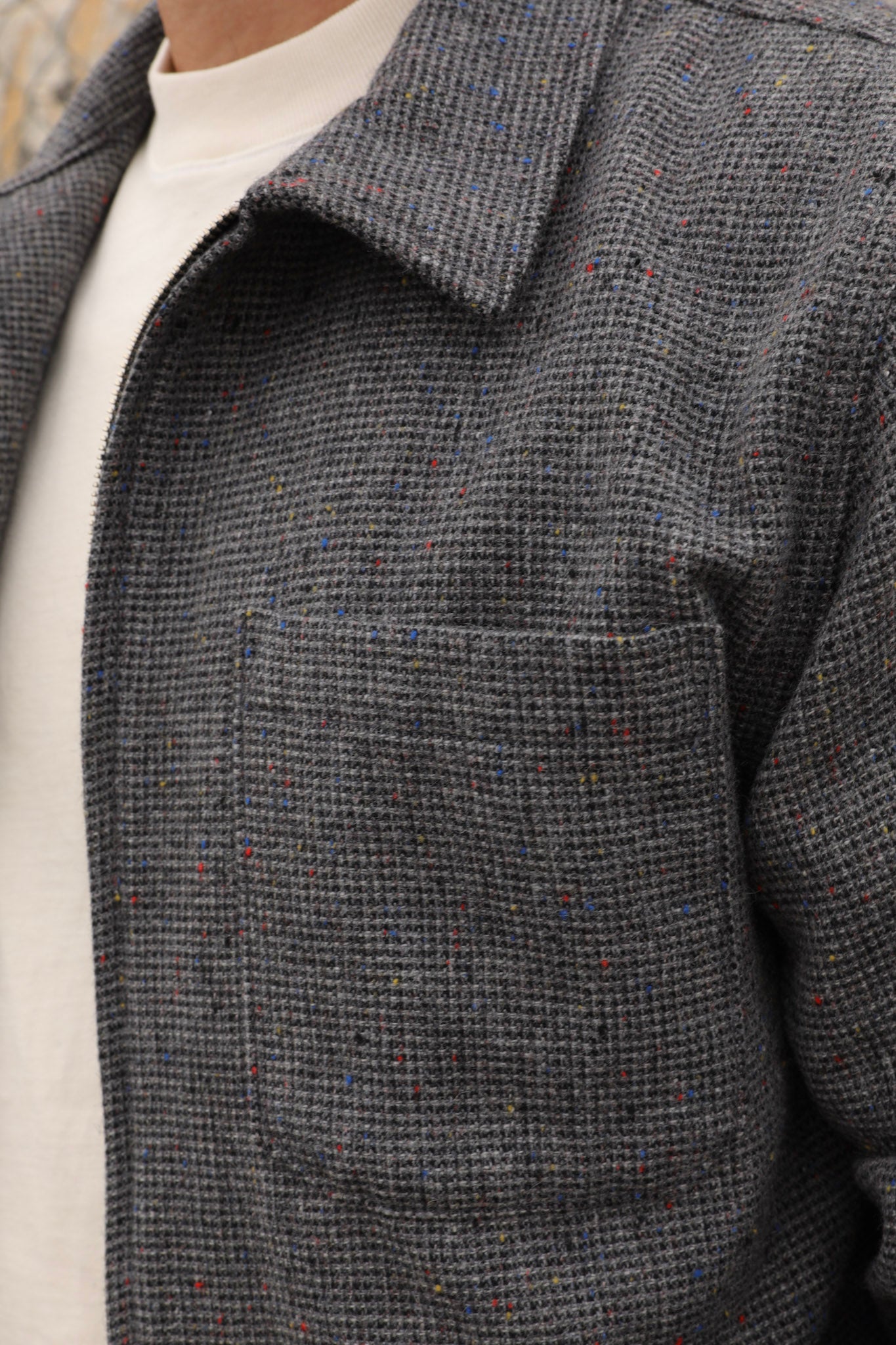 Close-up of a gray wool textured Signature Innovation jacket with a white shirt underneath